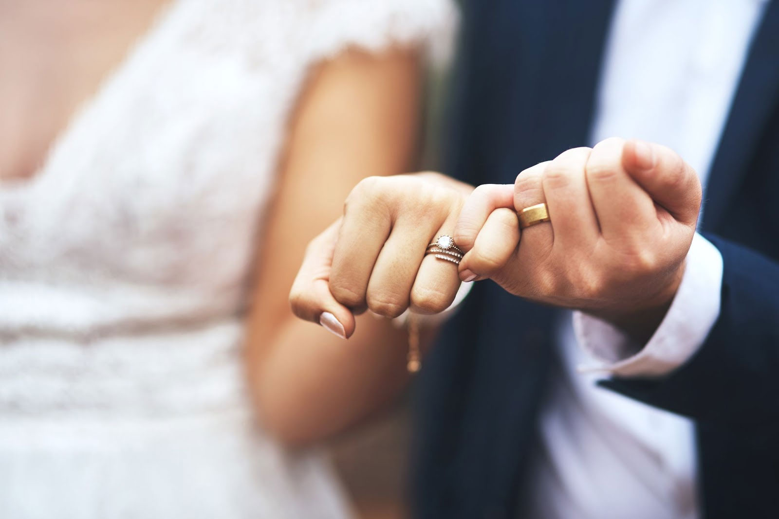 Couple holding hands showing wedding rings.